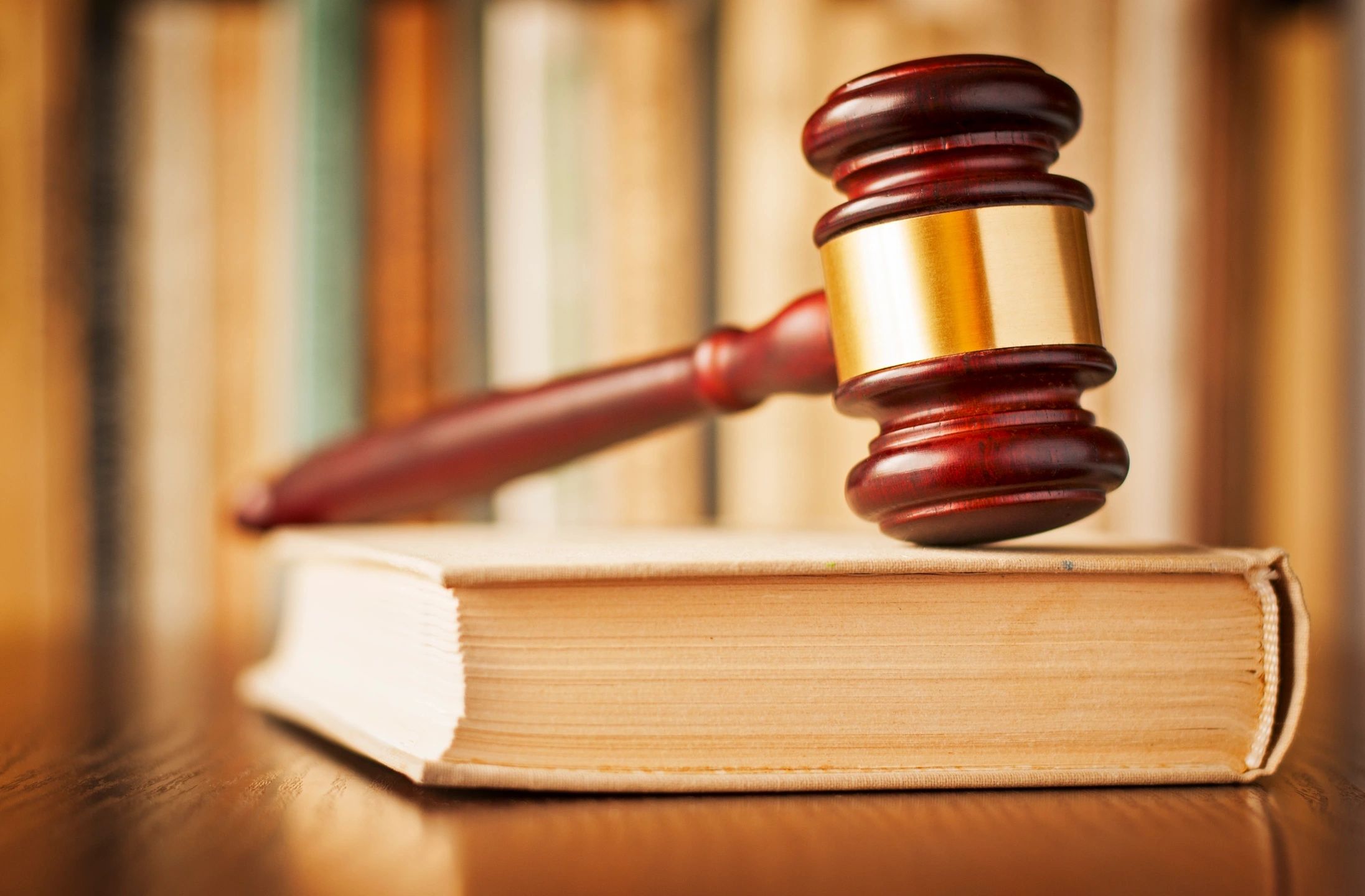 A judge 's gavel on top of an open book.